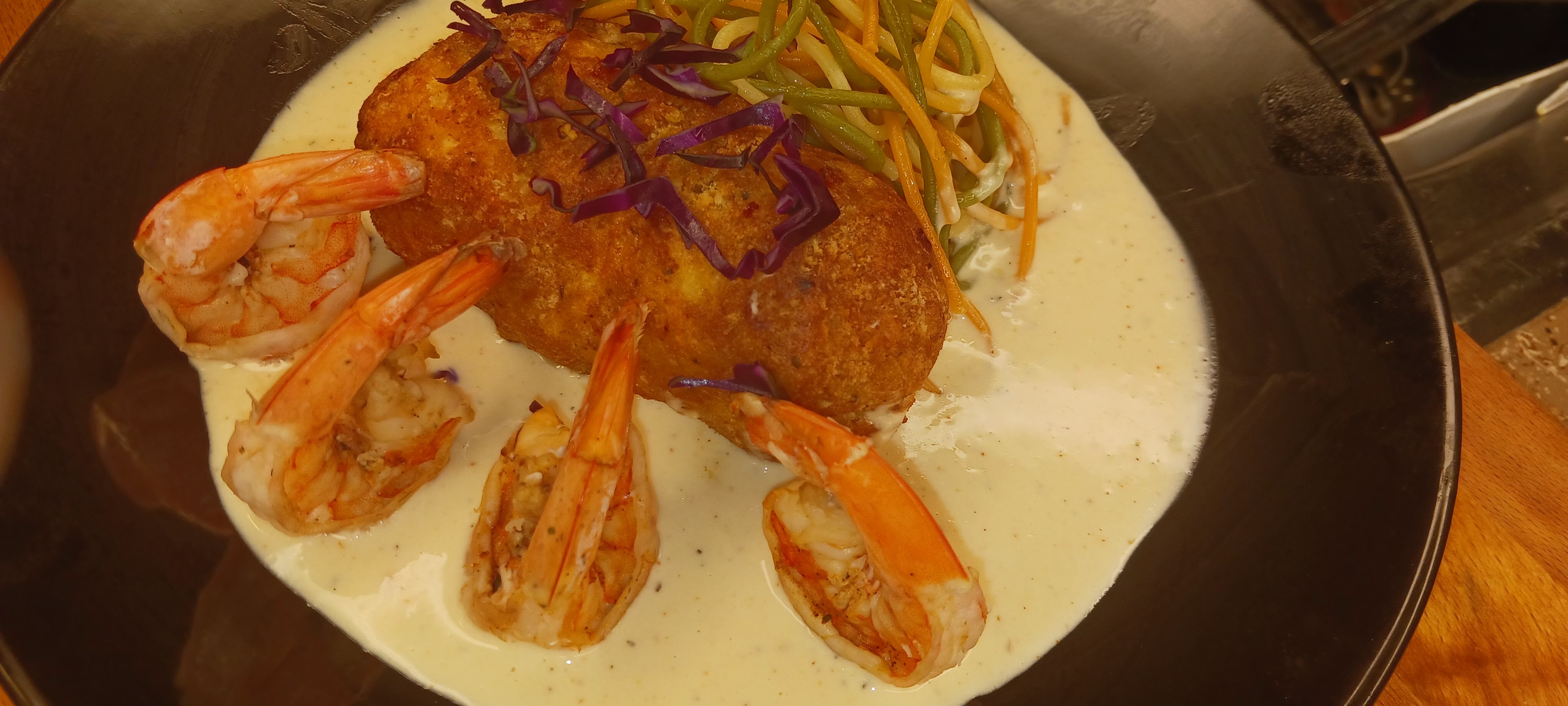 Crispy crab croquette with shrimp in cream sauce and vegetable slaw